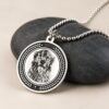 Silver Memorial Pendant — pendant resting on dark stones Silver Memorial Pendant — pendant resting on dark stones